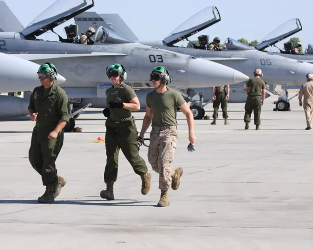 Men running and riding planes on the runway